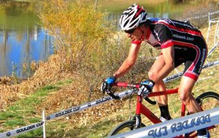Cyclist riding a Zinn Cycles cyclocross bike on a track by a lake
