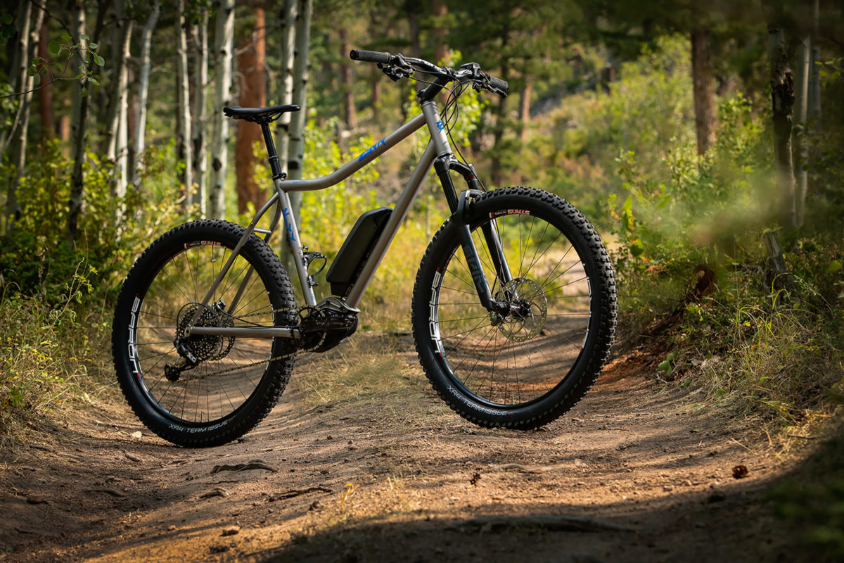 A custom titanium e-bike by Zinn Cycles on a mountain bike trail
