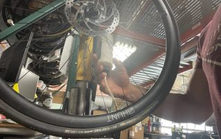 A bike mechanic working on a tire
