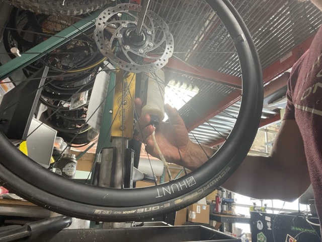 A bike mechanic working on a tire