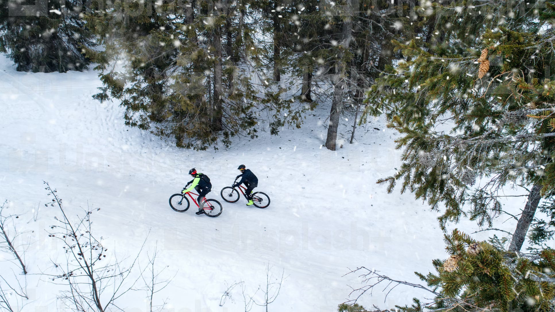 two people cycling in cold, snowy weather